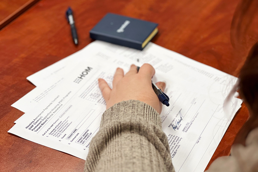 A woman signs a HAP contact with HOM